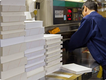 大きさをそろえるため断裁機で背を除く3辺をきれいに断裁します(化粧裁ち、といいます)。