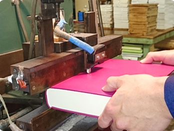 中身との接着部である溝に接着剤をひき、きっちりと合わせて表紙とくるみます。